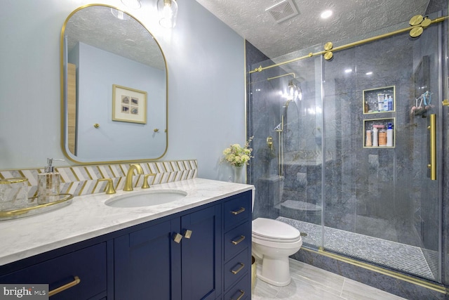 bathroom featuring toilet, a textured ceiling, tile patterned flooring, an enclosed shower, and vanity