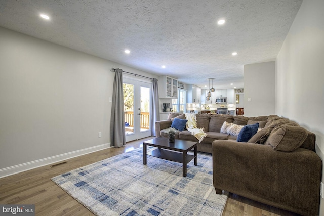 living room featuring french doors, a textured ceiling, and hardwood / wood-style floors