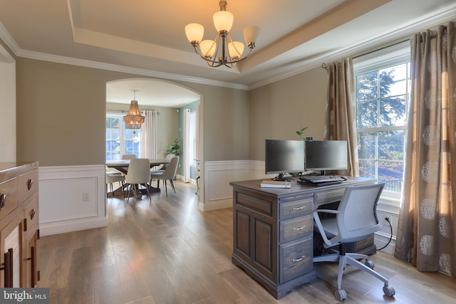 home office featuring ornamental molding, an inviting chandelier, a tray ceiling, and hardwood / wood-style floors