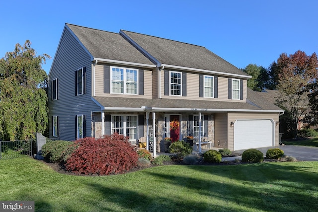 colonial inspired home with a garage, covered porch, and a front lawn