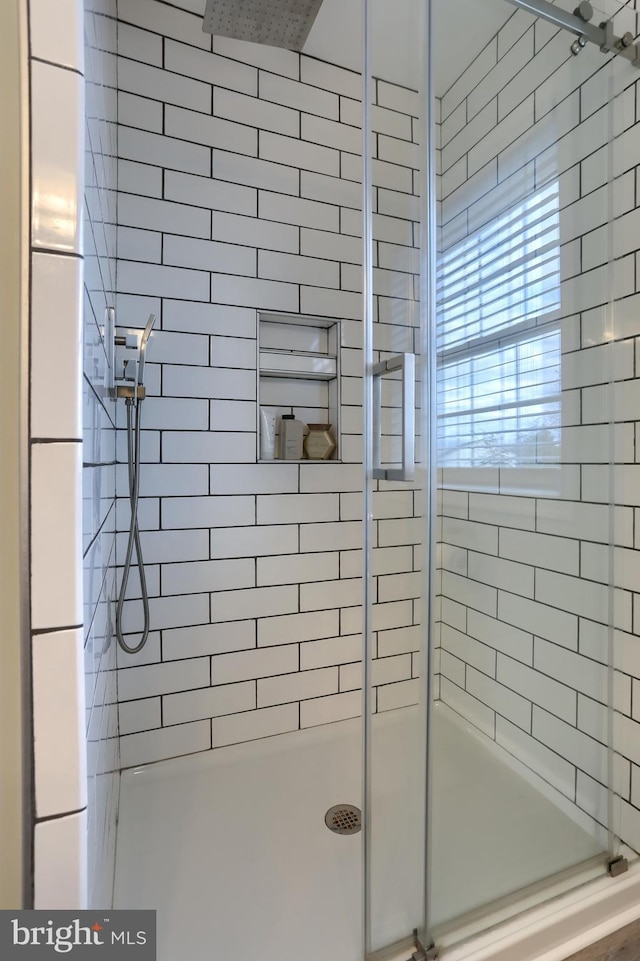 bathroom with a shower with door