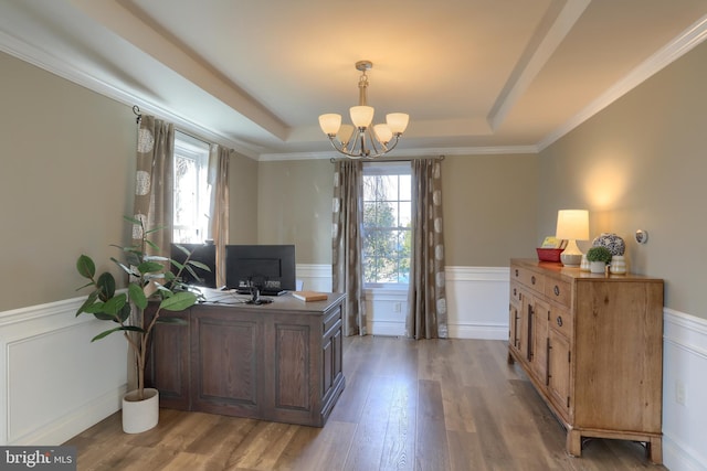 home office featuring wood-type flooring, an inviting chandelier, ornamental molding, and a tray ceiling