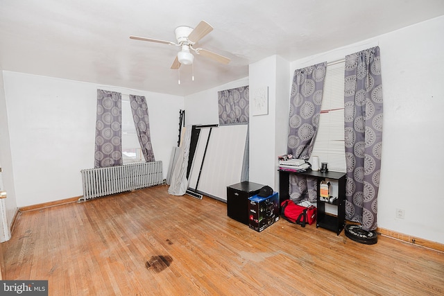 misc room featuring hardwood / wood-style floors, radiator, and ceiling fan