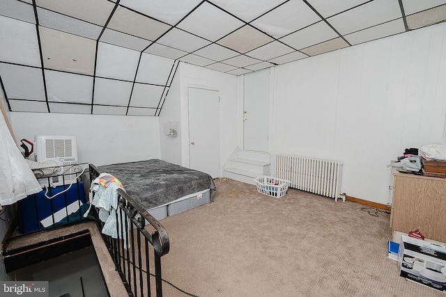 bedroom featuring radiator, carpet floors, and a paneled ceiling