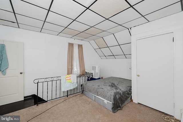 carpeted bedroom with a drop ceiling and vaulted ceiling