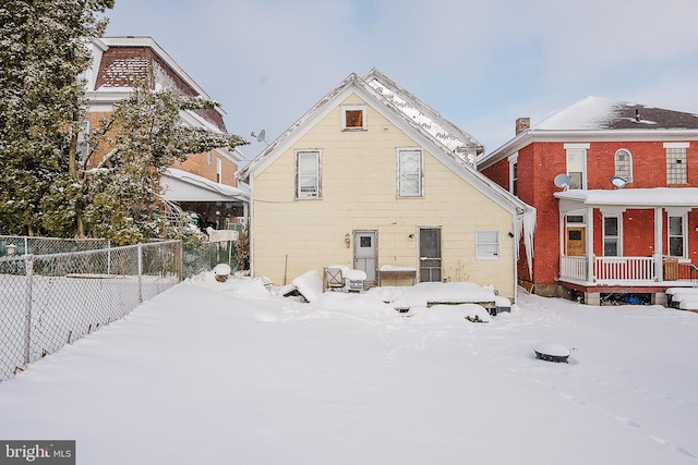 view of snow covered back of property