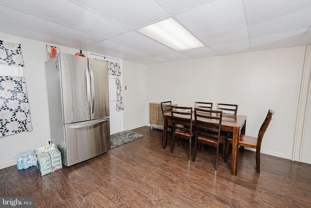 dining area featuring dark hardwood / wood-style flooring and a drop ceiling