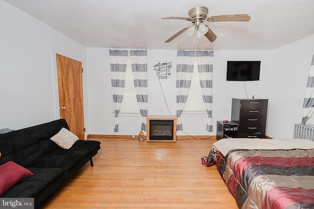 bedroom featuring ceiling fan, radiator heating unit, and hardwood / wood-style floors