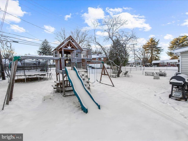 snow covered playground with a trampoline