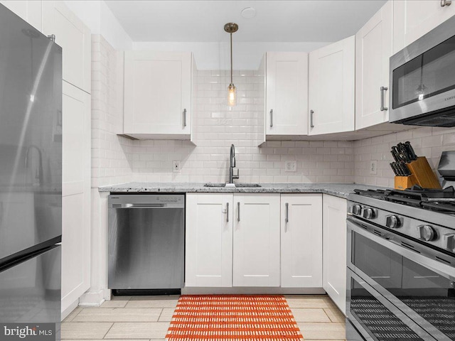 kitchen featuring stainless steel appliances, backsplash, white cabinets, and sink