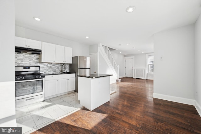 kitchen with appliances with stainless steel finishes, decorative backsplash, white cabinetry, and sink