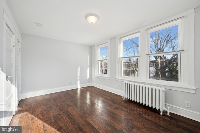 empty room with radiator and dark wood-type flooring