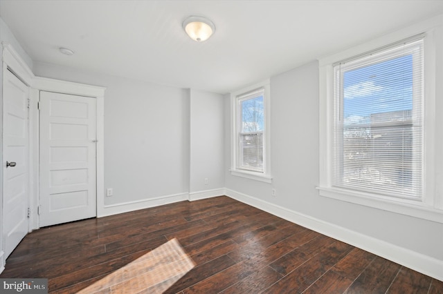 empty room with dark wood-type flooring