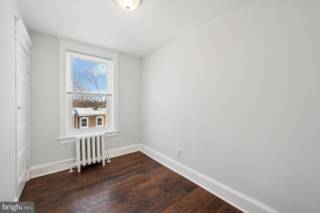 unfurnished room featuring dark wood-type flooring and radiator heating unit