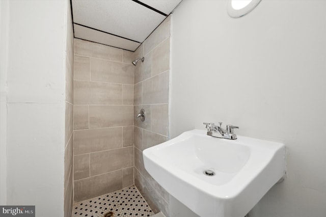 bathroom with sink and a tile shower