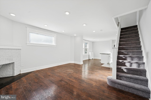 unfurnished living room with dark hardwood / wood-style flooring and a fireplace