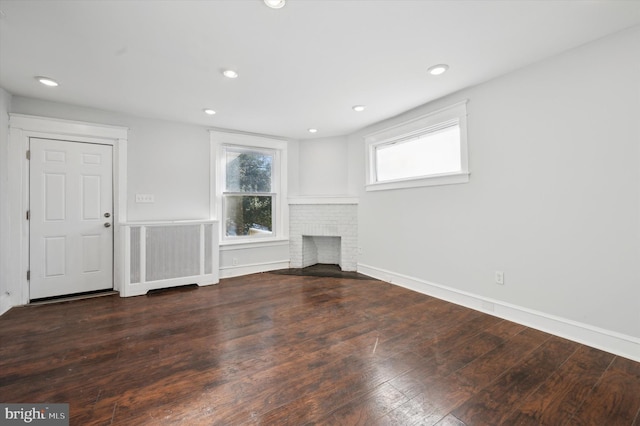 unfurnished living room featuring dark hardwood / wood-style flooring and a fireplace