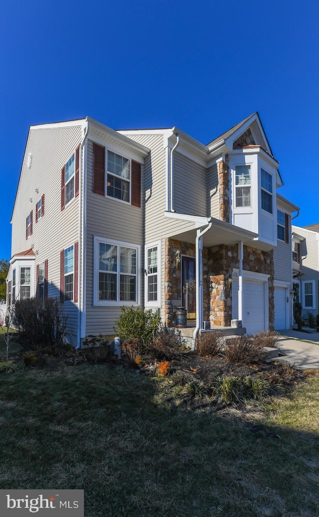 view of front of home featuring a front lawn, covered porch, and a garage