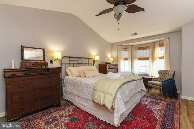 bedroom with ceiling fan, lofted ceiling, and wood-type flooring