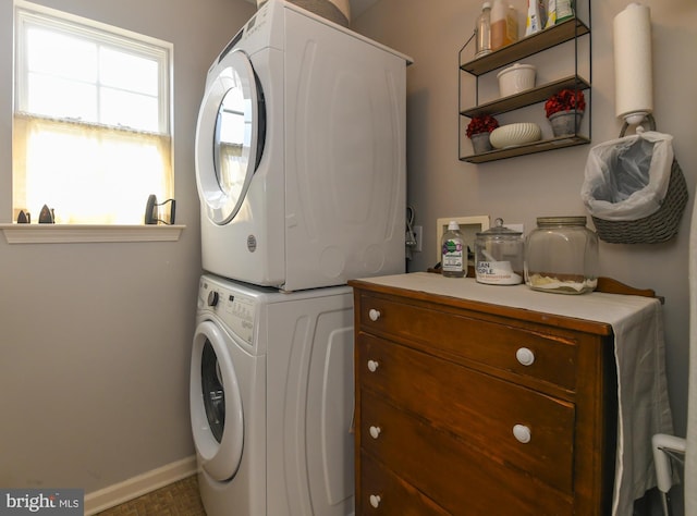 clothes washing area featuring stacked washer and dryer