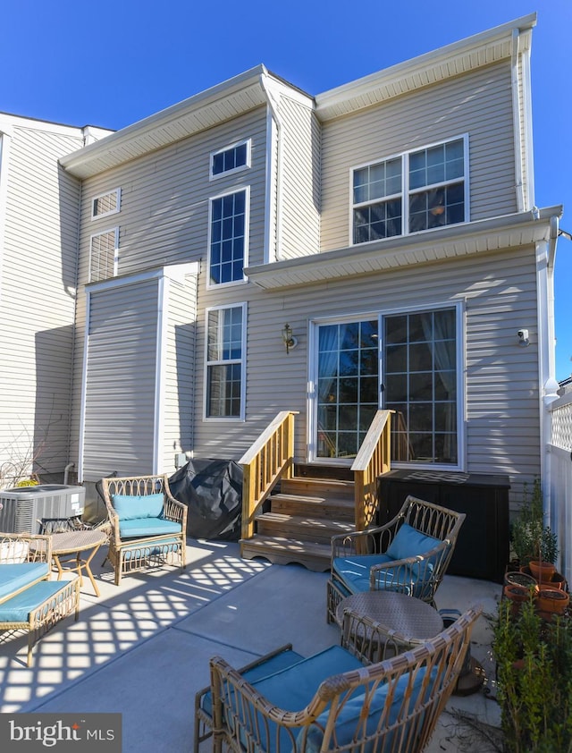 rear view of house with central air condition unit, an outdoor living space, and a patio area