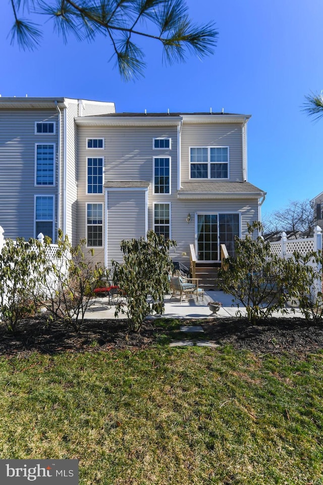 back of house with a lawn and a patio area