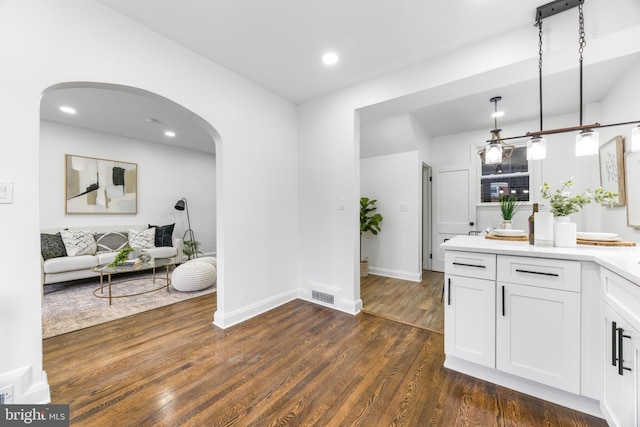 kitchen featuring white cabinets, dark wood-type flooring, and pendant lighting