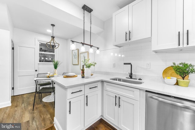 kitchen featuring white cabinetry, kitchen peninsula, decorative light fixtures, dishwasher, and sink