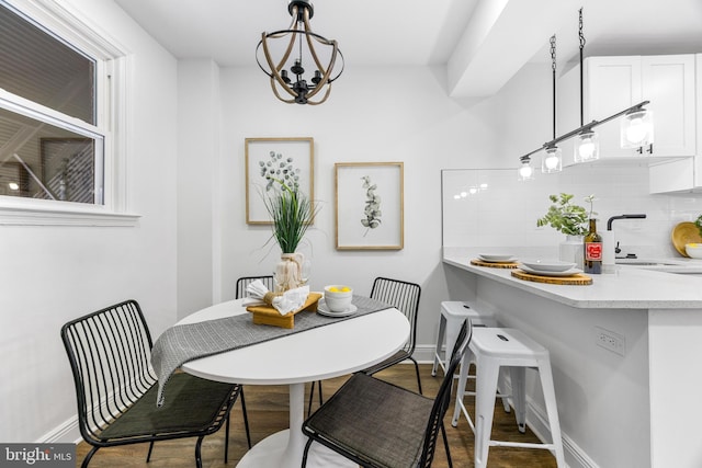 dining area featuring an inviting chandelier, wood-type flooring, and sink