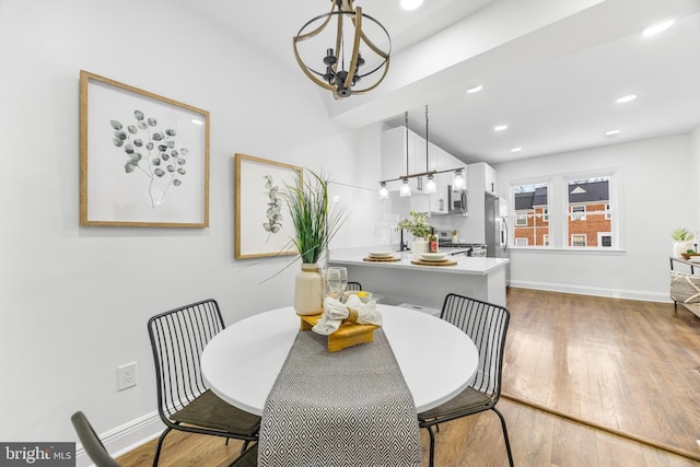 dining space with wood-type flooring and a notable chandelier