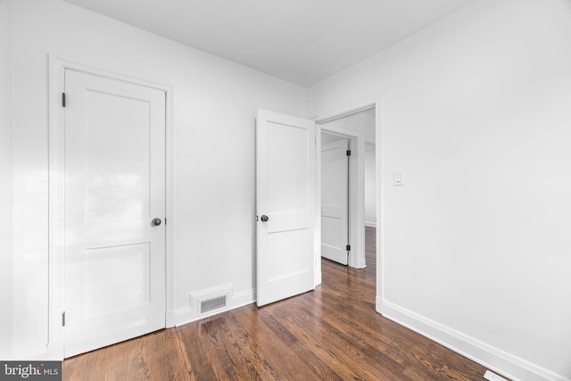 unfurnished bedroom featuring dark wood-type flooring