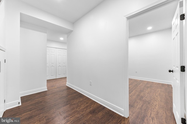 corridor with dark hardwood / wood-style flooring