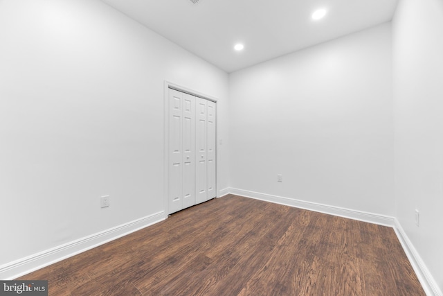 unfurnished room with dark wood-type flooring