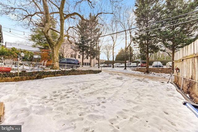 yard layered in snow featuring a playground