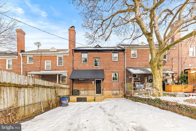 snow covered back of property with cooling unit