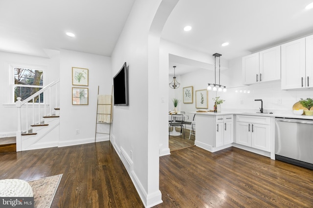 kitchen with pendant lighting, dishwasher, white cabinetry, tasteful backsplash, and sink