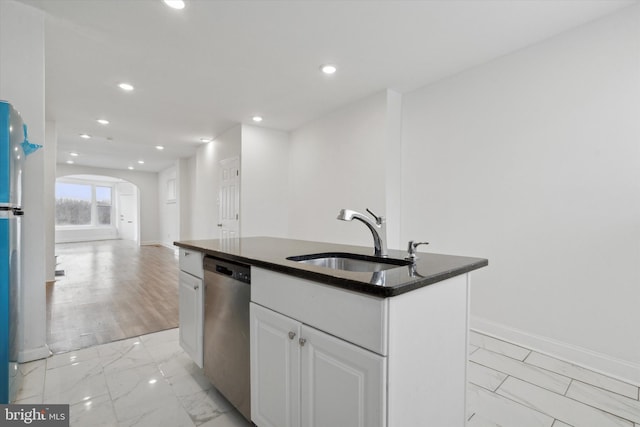 kitchen with stainless steel dishwasher, sink, a center island with sink, and white cabinets