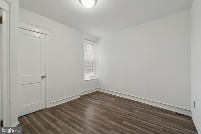 unfurnished room with dark hardwood / wood-style floors