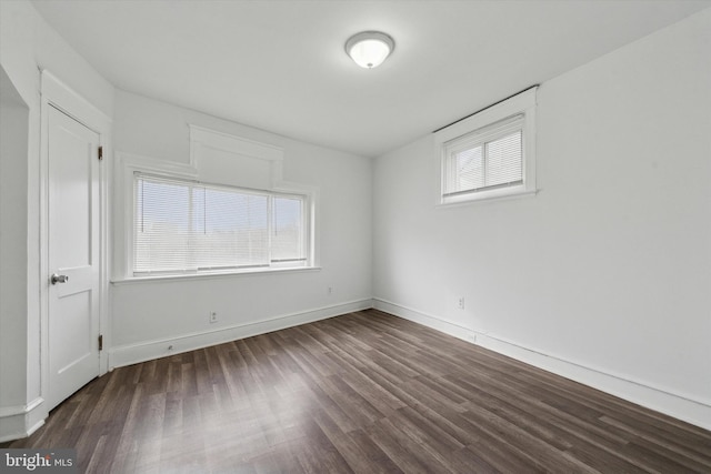 empty room featuring dark hardwood / wood-style flooring and a wealth of natural light