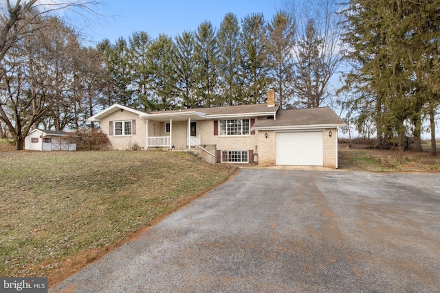 view of front of house with a front yard, a garage, and covered porch