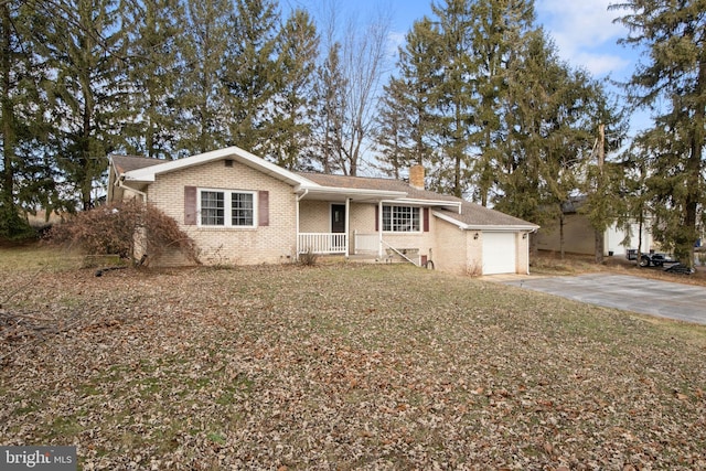 ranch-style home with a porch, a front lawn, and a garage