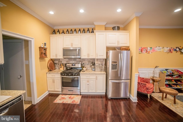 kitchen with white cabinetry, ornamental molding, tasteful backsplash, dark hardwood / wood-style flooring, and appliances with stainless steel finishes