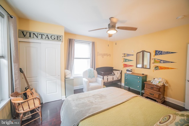 bedroom with ceiling fan, a closet, and dark hardwood / wood-style flooring