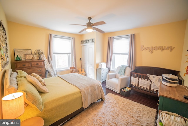 bedroom with ceiling fan, hardwood / wood-style floors, and multiple windows