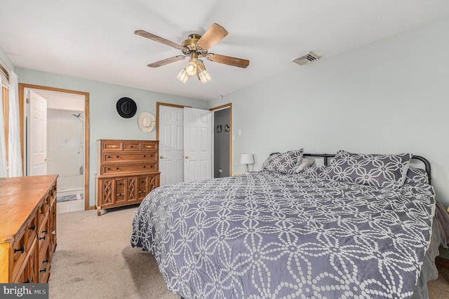 carpeted bedroom featuring ceiling fan, ensuite bathroom, and a closet