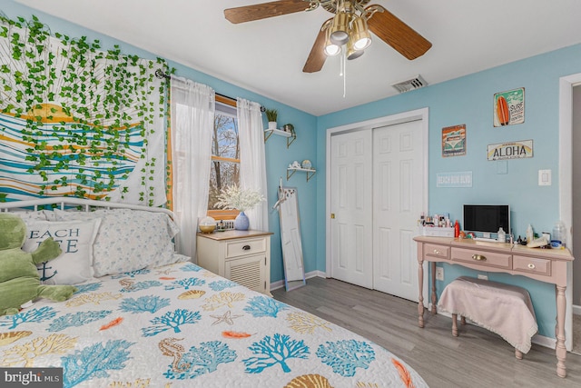 bedroom with ceiling fan, a closet, and wood-type flooring