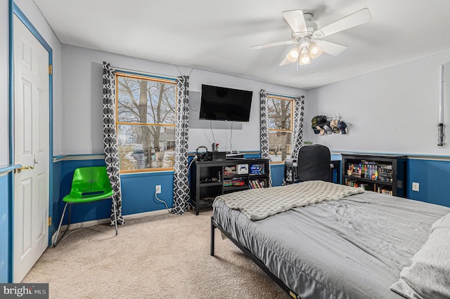 bedroom featuring ceiling fan, multiple windows, and carpet flooring