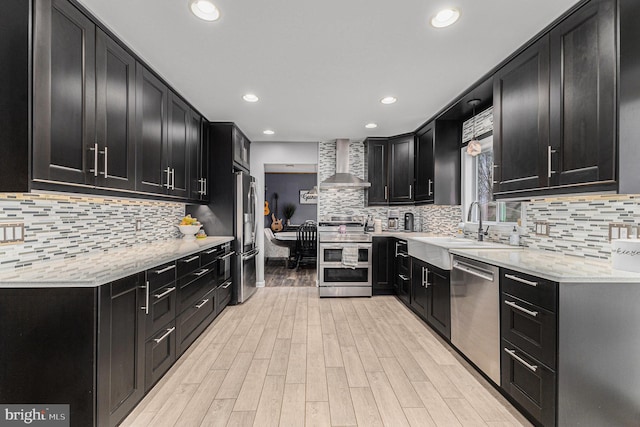 kitchen with tasteful backsplash, appliances with stainless steel finishes, sink, and wall chimney exhaust hood