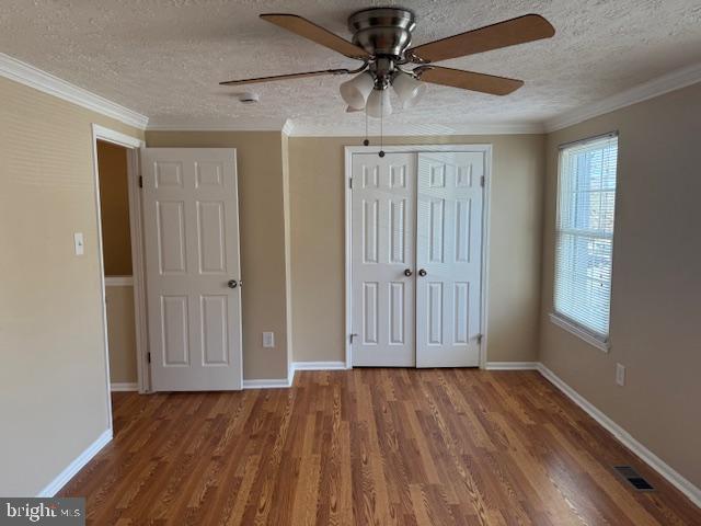 unfurnished bedroom with hardwood / wood-style flooring, ceiling fan, and a textured ceiling