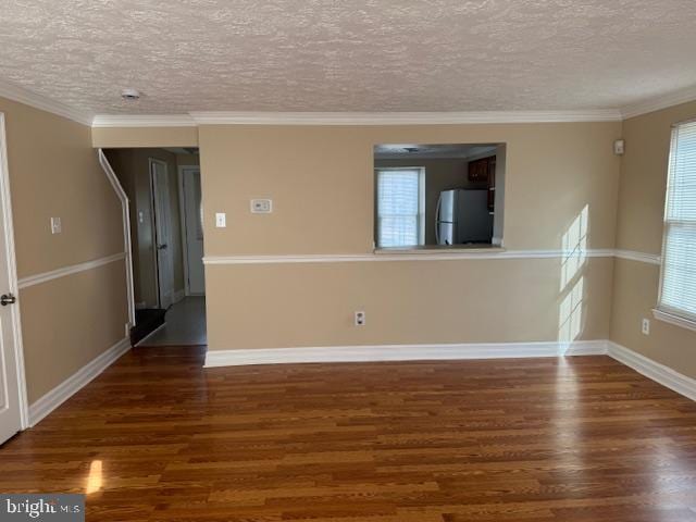 unfurnished room with dark hardwood / wood-style flooring, ornamental molding, and a textured ceiling